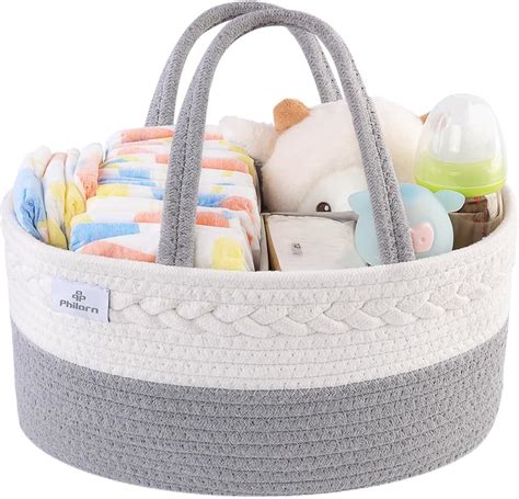 Una moderna nursery organizzata con un cestino per pannolini posizionato vicino al fasciatoio