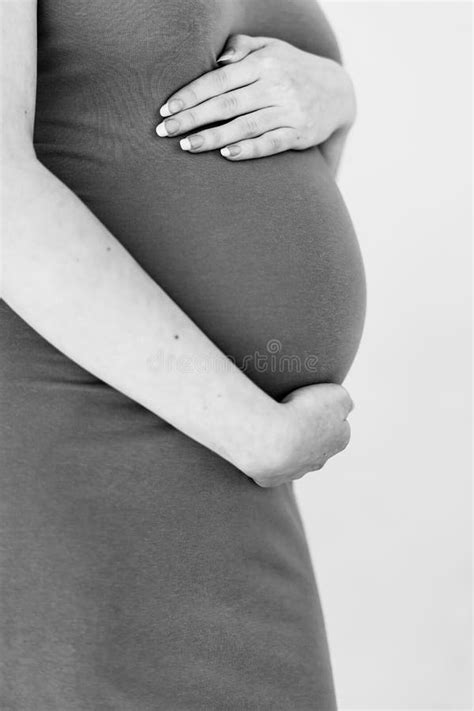 Pregnant woman holding her belly, representing maternal health