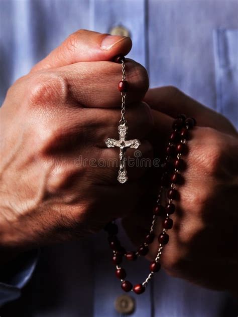 Mani di bambino che stringono un rosario