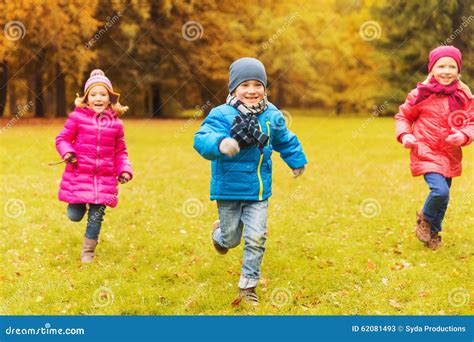 Bambini che giocano e corrono felicemente all'aperto con indosso magliette colorate, inclusa una rossa