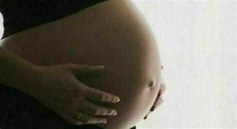 donna incinta che si tocca il pancione con espressione serena
