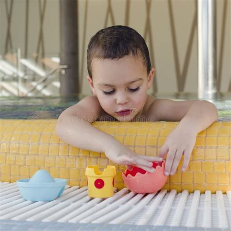 Bambino che gioca felice in piscina indossando un pannolino da bagno