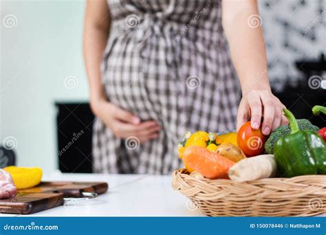 Donna incinta che sceglie alimenti sani e vari in cucina