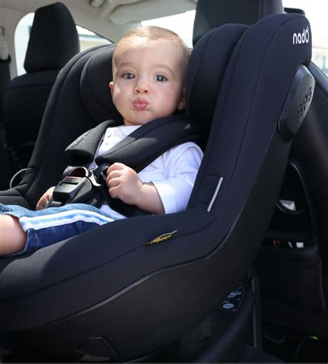 Bambino in un seggiolino auto Migo con logo Migo in evidenza