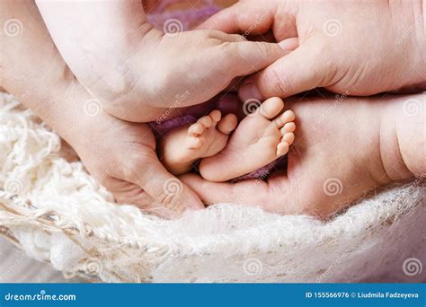 Mani di genitori che tengono i piedi di un neonato