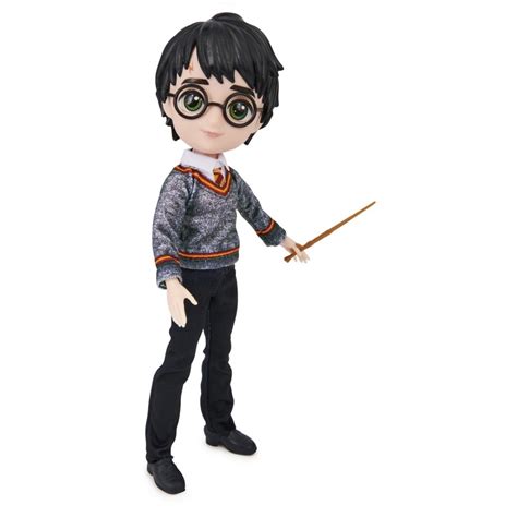 Un bambino che indossa la divisa di Hogwarts completa di sciarpa e bacchetta magica
