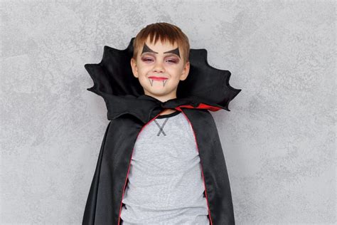Bambino con mantello da vampiro e trucco