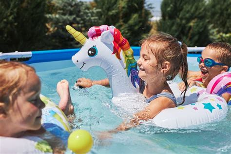 bambini che giocano felici in una piscina durante una giornata di sole estiva