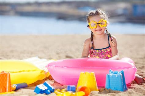 bambina che gioca sulla spiaggia con un colorato costume da bagno