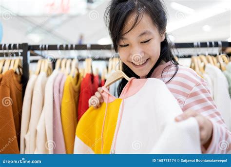 Una bambina che sceglie i propri vestiti da un armadio colorato e ben organizzato