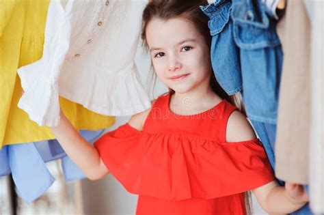Bambina che sceglie i vestiti nel guardaroba