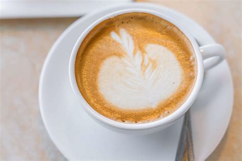 Un cappuccino cremoso con la schiuma decorata, servito al Bar Ovvio Colico