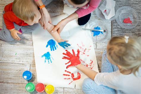 bambini che dipingono con le dita su grandi fogli