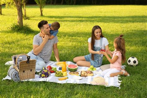 Famiglia che fa un picnic con un cesto pieno di cibo