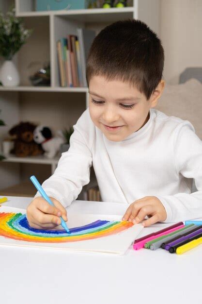 Un bambino concentrato mentre disegna il percorso su un foglio con un labirinto stampato