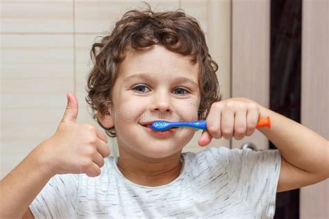 bambino che lava i denti con lo spazzolino sotto la supervisione di un genitore