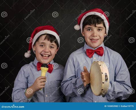 Bambini che cantano canzoni natalizie con campanellini