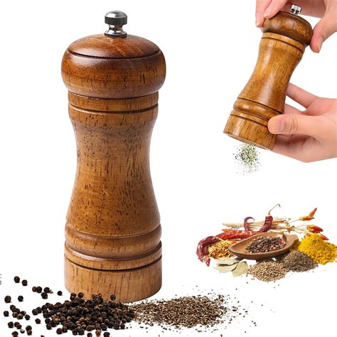 Macinapepe in legno vicino a grani di pepe nero e bianco