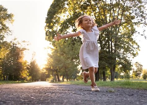 Bambina che corre felice in un parco indossando scarpe ergonomiche