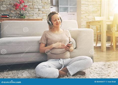 Una donna incinta che ascolta musica in un ambiente sereno