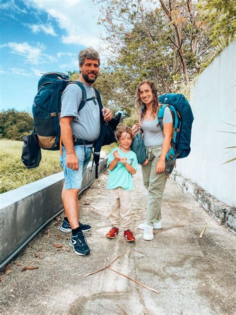 Famiglia con zaino porta-bimbi che cammina in un vicolo di Santorini
