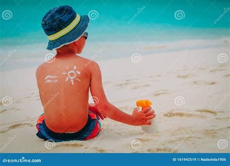 Bambino con crema solare che gioca in spiaggia