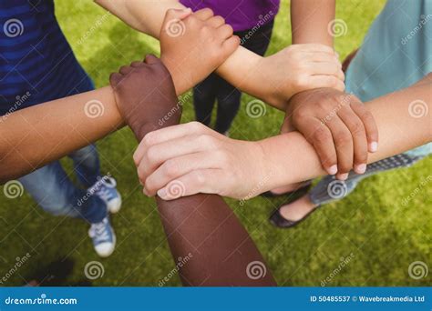 Bambini di diverse etnie che si tengono per mano intorno al globo