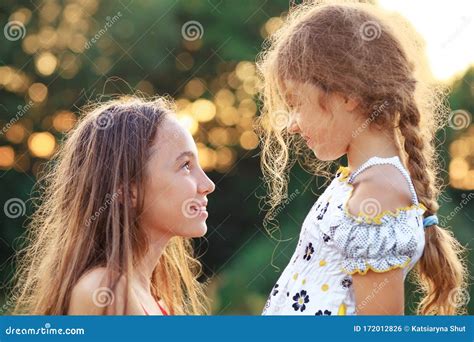 Bambine che guardano felici una vetrina di scarpe colorate