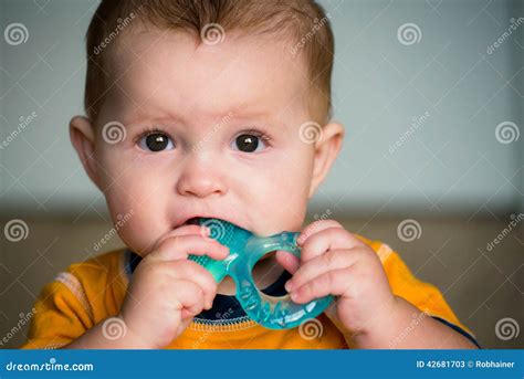 Bambino che morde un anello da dentizione