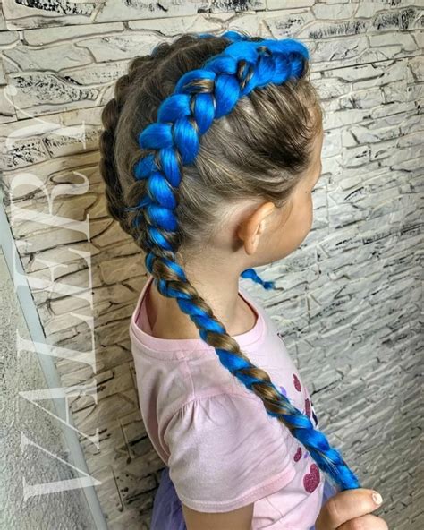 Bambina con acconciature a trecce ed elastici colorati