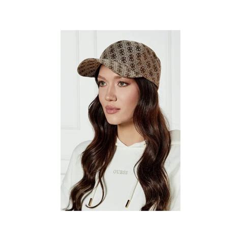 Un elegante cappello invernale Guess indossato da una bambina in un contesto cittadino alla moda, mettendo in risalto il logo distintivo del brand.