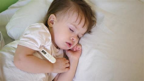 Bambino che dorme con termometro