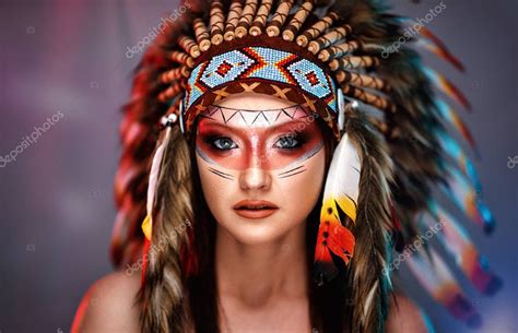 ragazza con trucco da indiana e piume tra i capelli
