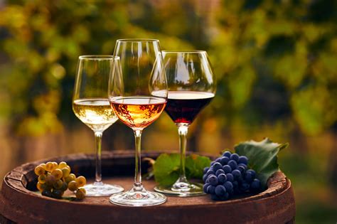 Dettaglio di calici di vino bianco e rosso disposti sul bancone in legno del locale