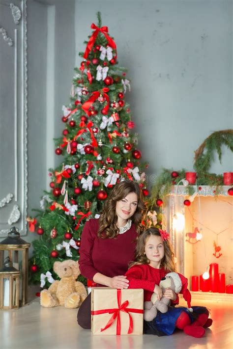 bambini che scartano regali sotto l'albero di Natale