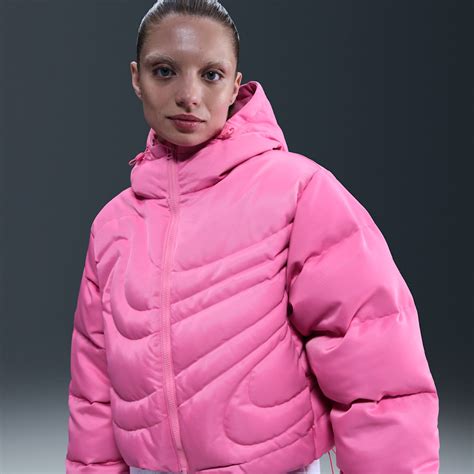 Una bambina che indossa un piumino rosa Nike in un parco invernale