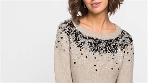 Primo piano di dettagli di paillettes e ricami su un maglione Guess