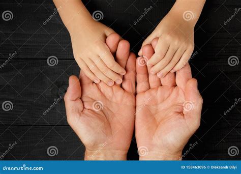 Mano di un adulto che tiene la mano di un bambino con un biglietto d'auguri