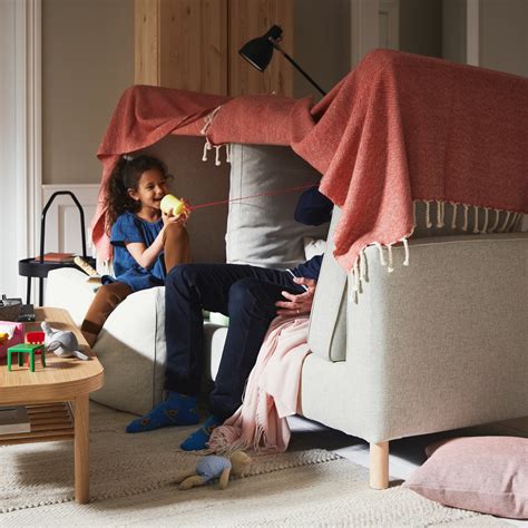 bambini che giocano in salotto con cuscini e coperte