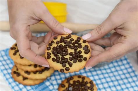 bambino che decora biscotti con gocce di cioccolato