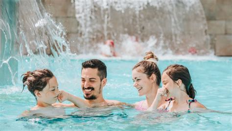 Famiglia felice in piscina termale con bambini