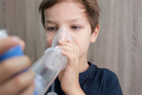 Bambino che usa distanziatore per inalatore
