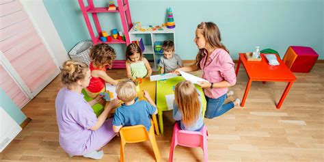 Educatore di asilo nido in interazione con i bambini durante un'attività sensoriale