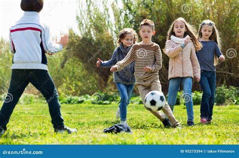 Bambini che giocano a calcio sorridendo su un campo da gioco