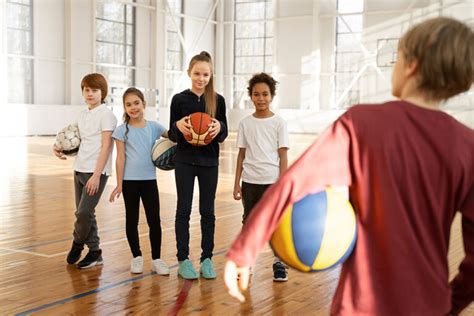 Bambini che eseguono un dribbling con la palla e lo sguardo alto