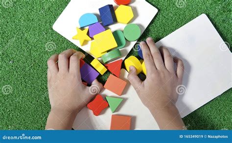 bambino che gioca con forme geometriche colorate su un tavolo luminoso