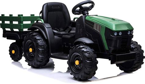 Bambino che utilizza il rimorchio del proprio trattore elettrico per trasportare giocattoli in un ambiente esterno