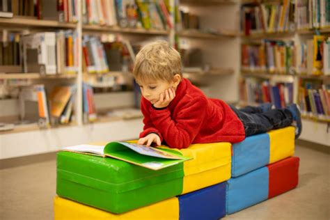 bambino che legge immerso in una biblioteca colorata