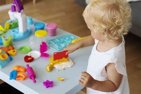 bambino che gioca con un tavolino attività colorato in una stanza luminosa
