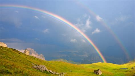Un arcobaleno che squarcia un cielo nuvoloso, simbolo di rinascita e speranza dopo un momento di buio.